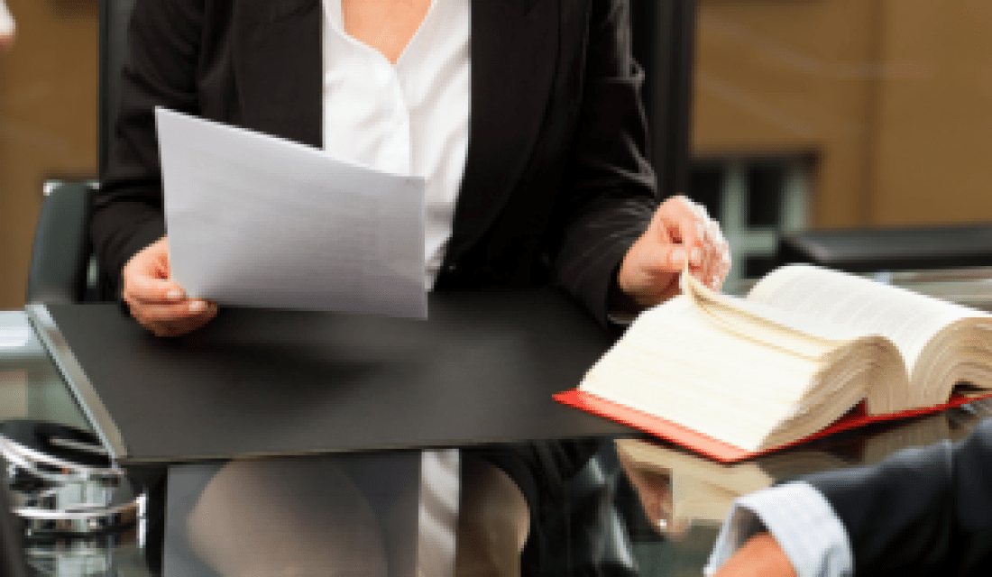 Frau schaut auf einen Brief und ein Gesetzbuch