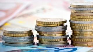 Gestapelte Münzen auf Geldscheinen