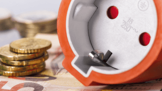 orangener Stecker liegt auf Bargeld